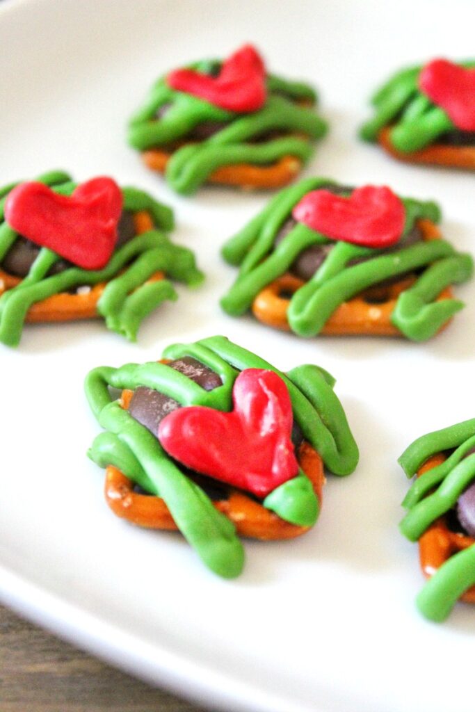 These Grinch Pretzel snack bites are the perfect thing to serve for a Grinch Movie Night or Christmas party treat. A bite-size Grinch snack everyone enjoys, sweet and salty Grinch Pretzel Bites drizzled with chocolate makes a Grinch Treat you can't stop eating, Grinch Party Food